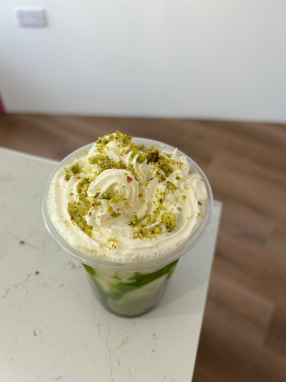 Matcha milk boba tea with whipped cream and matcha powder at Shakes Gravesend
